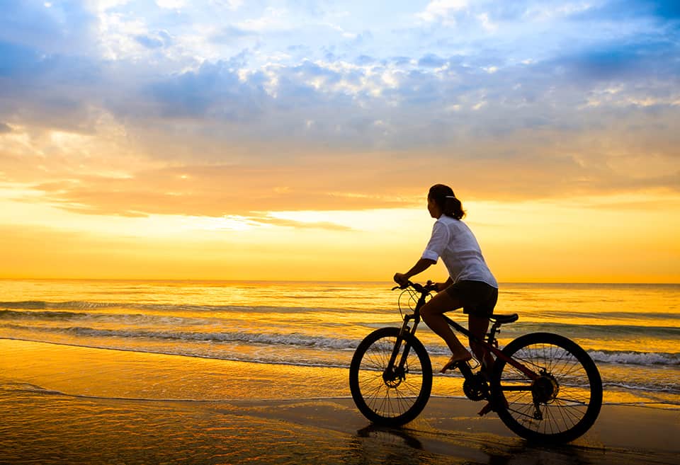 Person riding bike on the beach