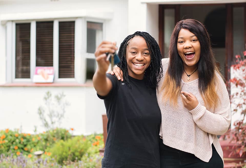 Portrait of couple holding up their keys after buying a new home