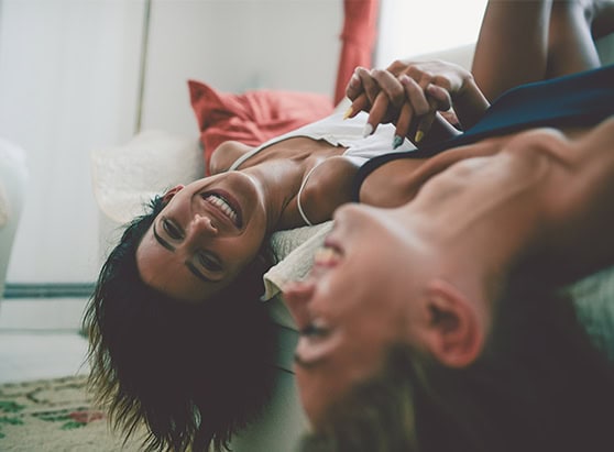 Couple smiling and laughing while sitting upside down on the couch