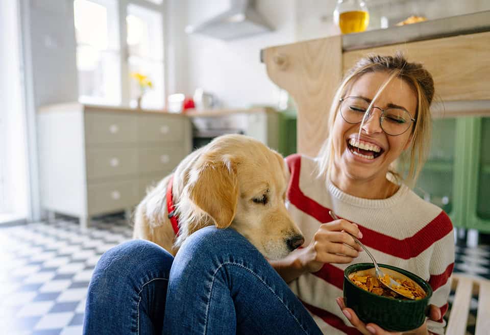 Person and their dog laughing in their new home