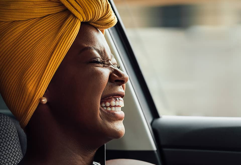 Person smiling in car after getting an auto loan