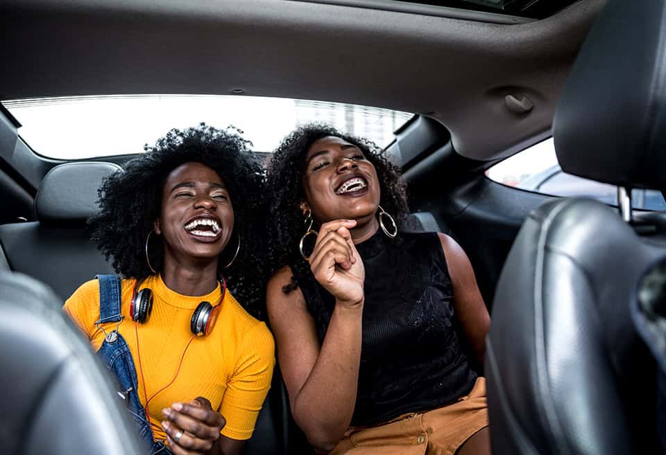 Two friends laughing inside a car