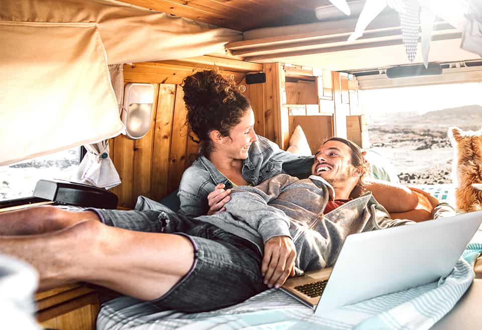 Couple laughing and laying down inside their RV