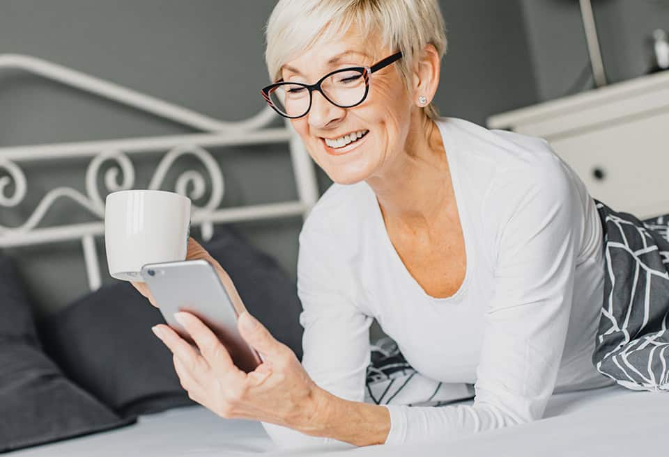 Woman Relaxing with Coffee while she manages her money with BluPeak Credit Union digital banking