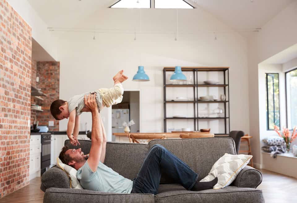 Father holding up baby in new house after buying a new home