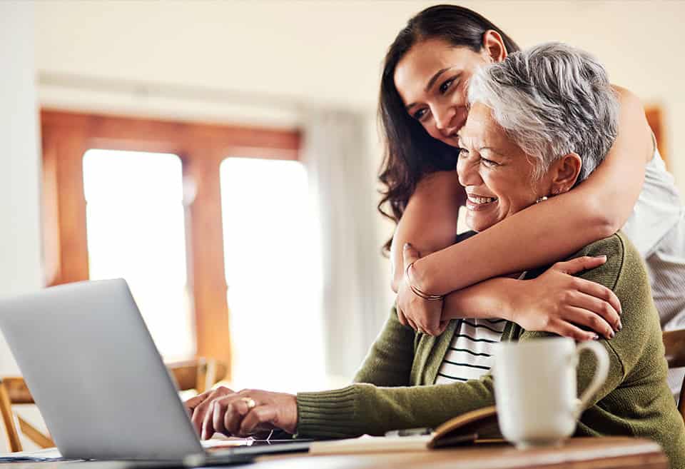 Mother and grown daughter hugging, maintaining their financial health during the pandemic