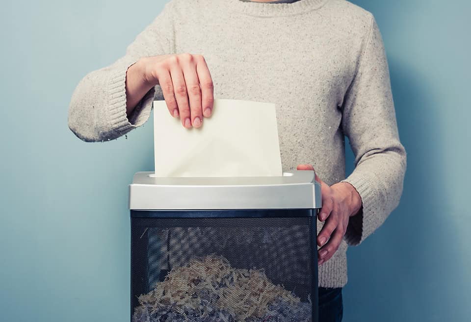 Person shredding their secure paperwork, keeping their financial data safe