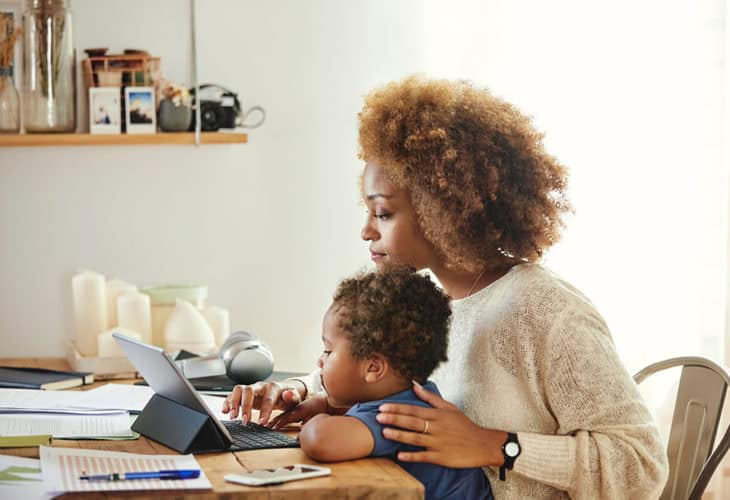 Mom and son looking at a tablet at their kitchen table, learning how to keep their information safe.