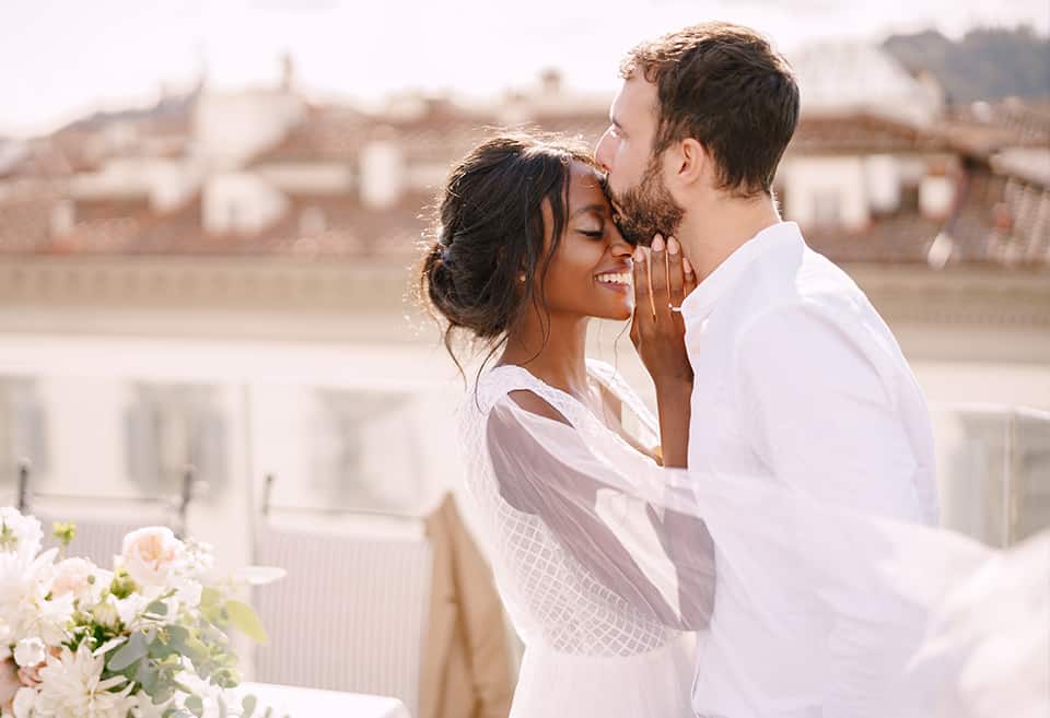 Wedding portrait of groom kissing bride