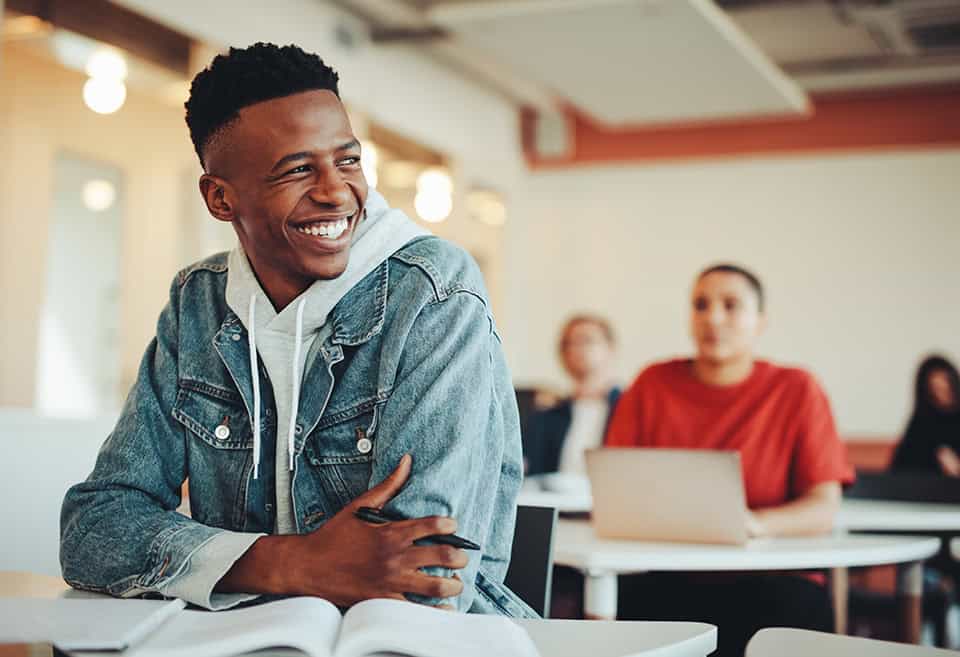 Student smiling at their desk