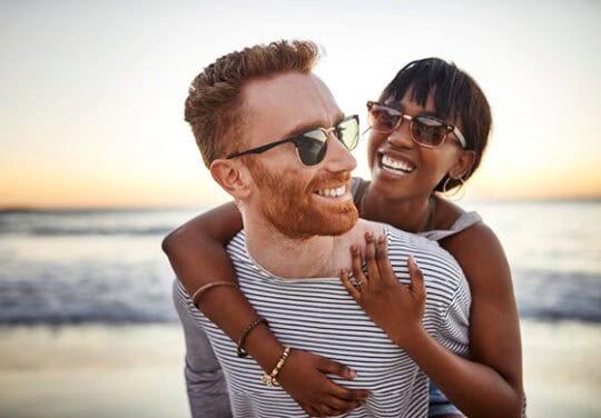 Couple laughing at the beach.