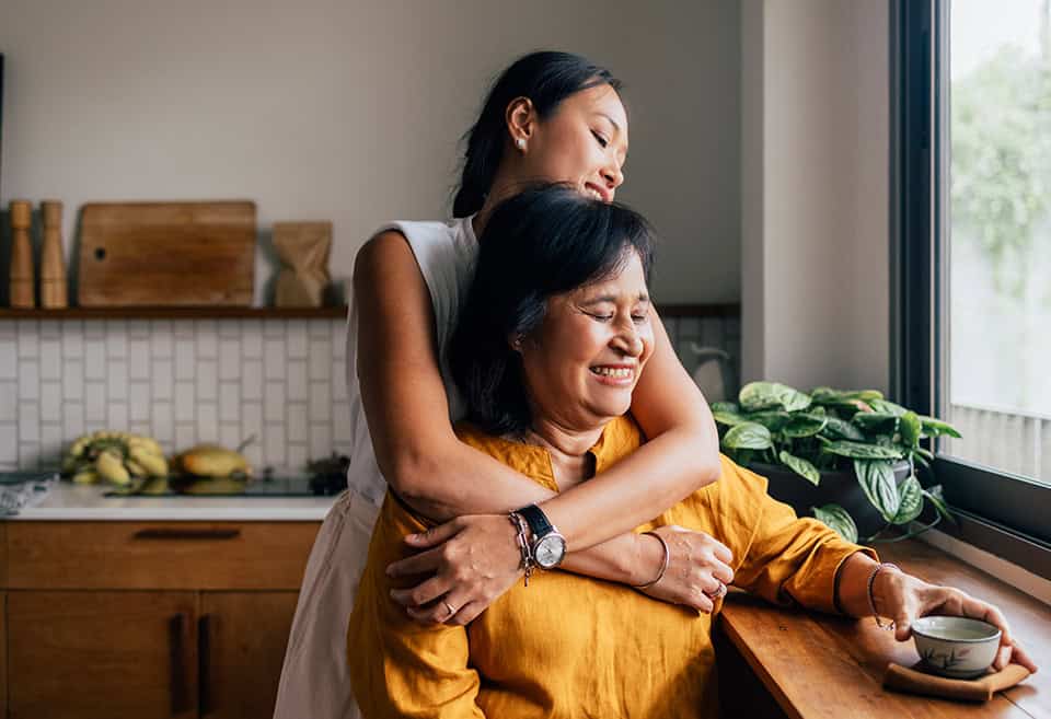 Parent and adult hugging and drinking tea