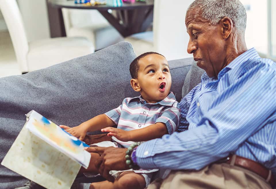 Grandfather reading a book to his grandchild