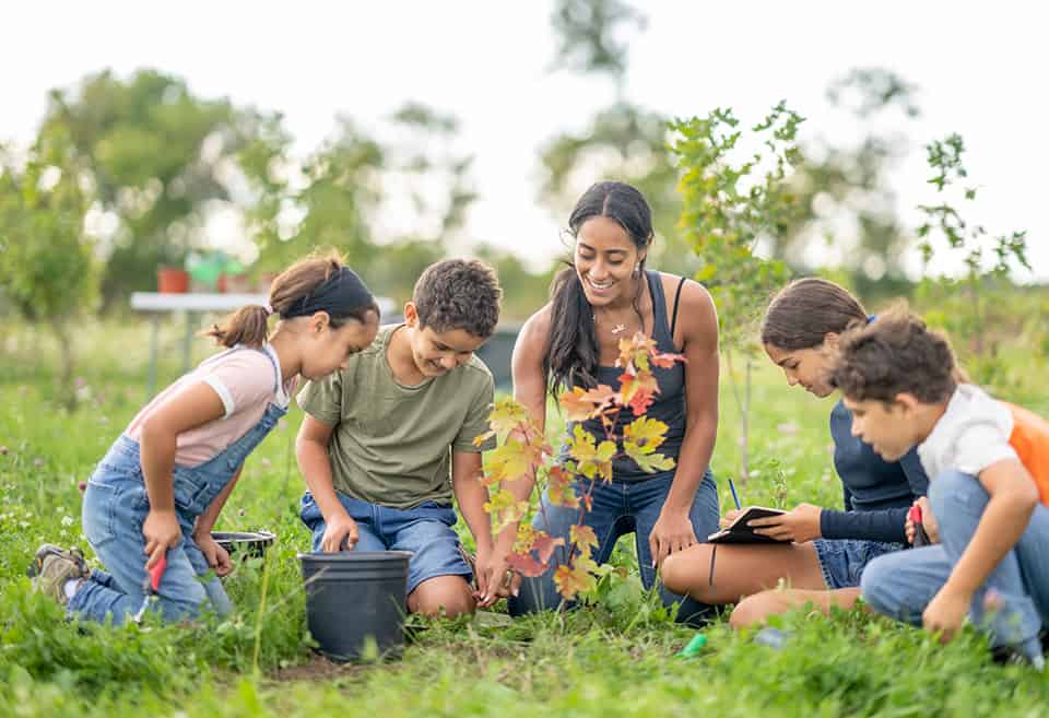 Community volunteer teaching children how to garden