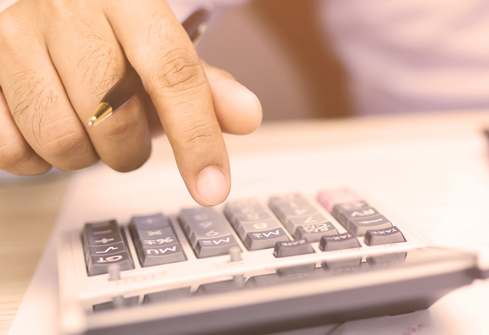 Person typing on calculator