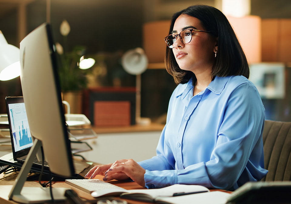 Woman working on computer blue shirt