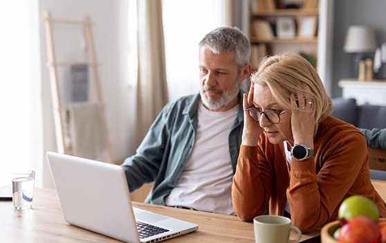 Concerned mature couple on laptop