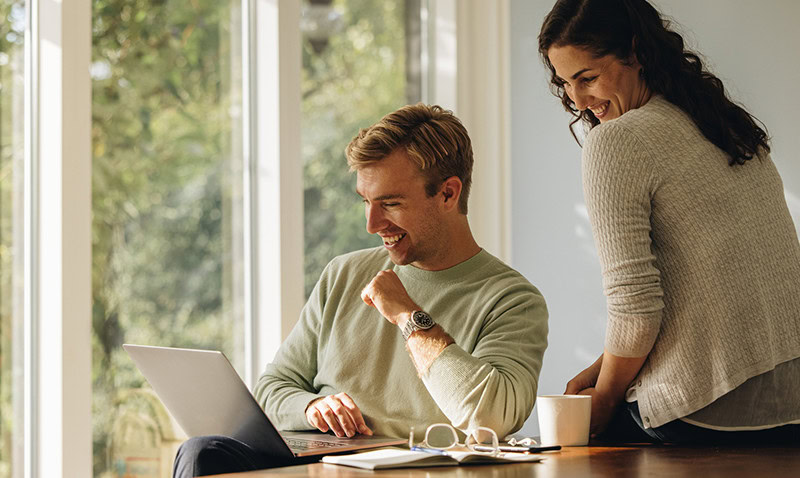 Couple sitting at table on laptop