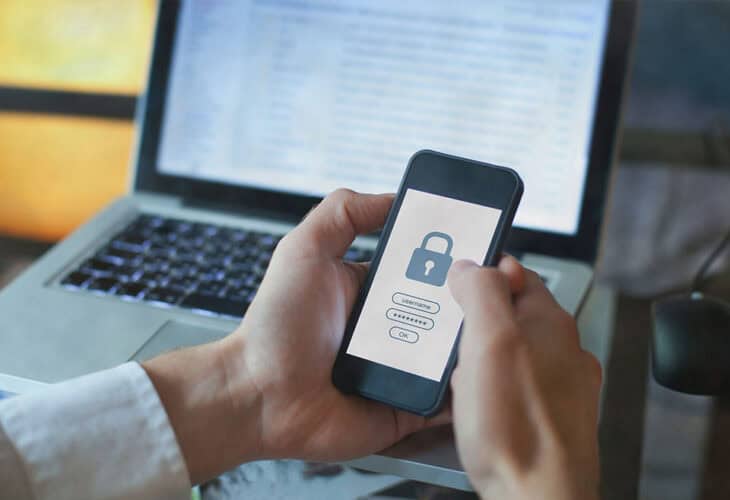 Man holding cell phone checking his login credentials