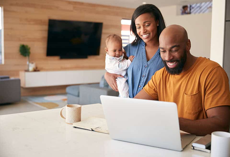 Family gathered around laptop for financial planning