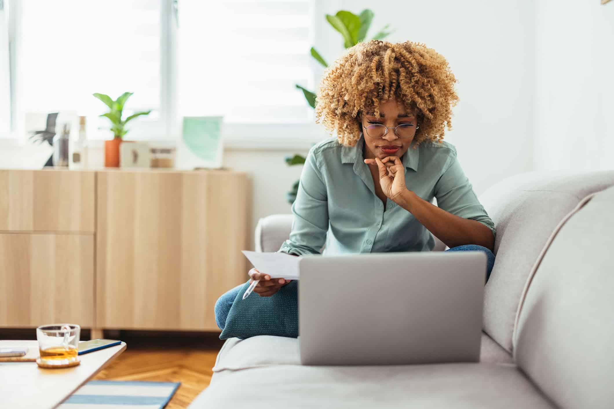 A person sits in from of a laptop computer researching how to lower their monthly bills.