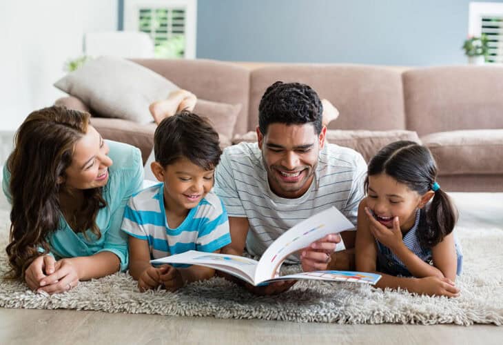 A family of four reading a book