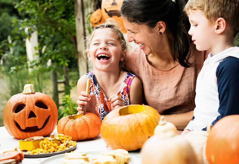 Family carving pumpkins and laughing