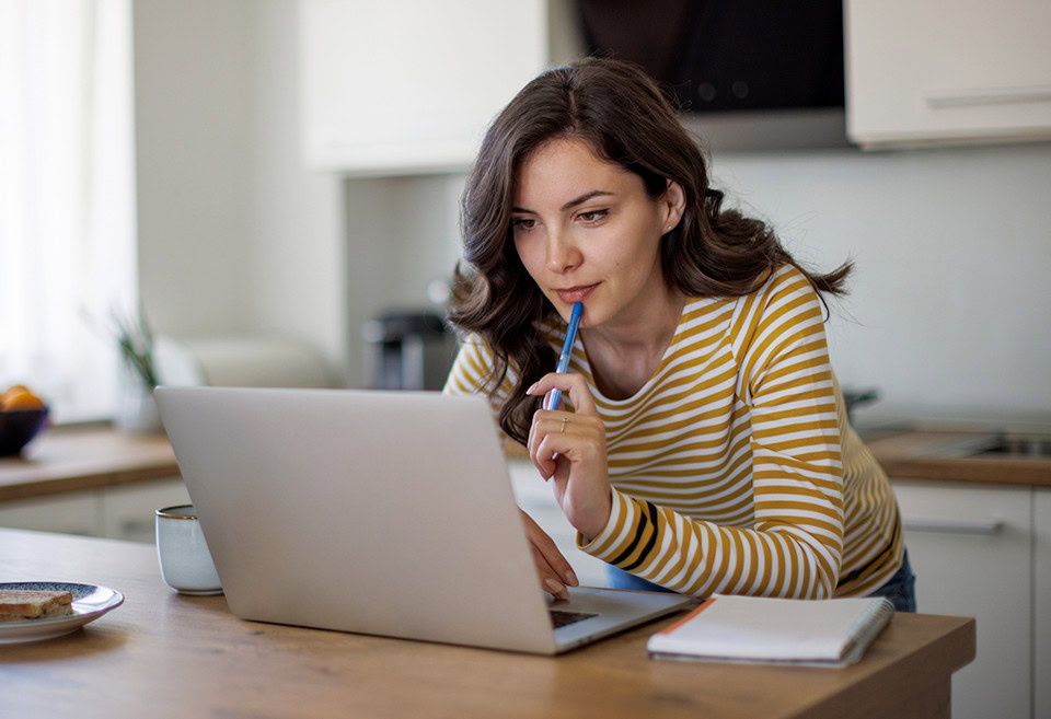 Woman on laptop with notepad