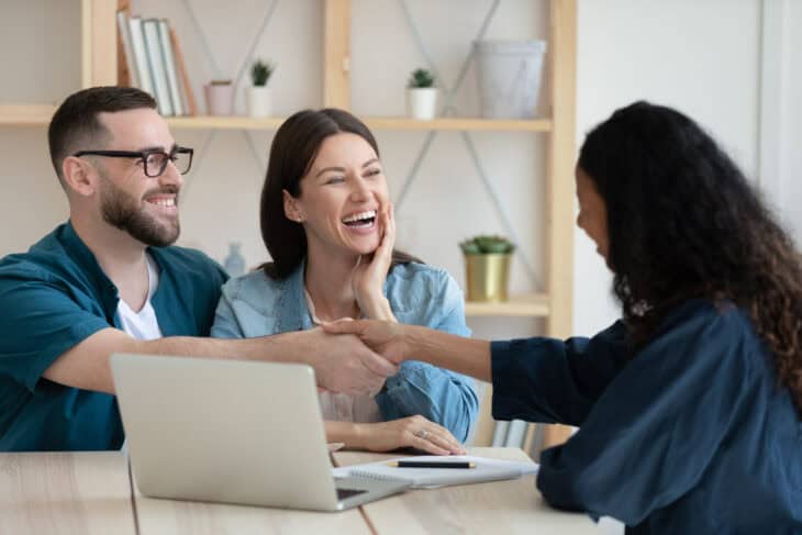 A couple shakes hands with a financial advisor after transitioning their bank account to a credit union account.