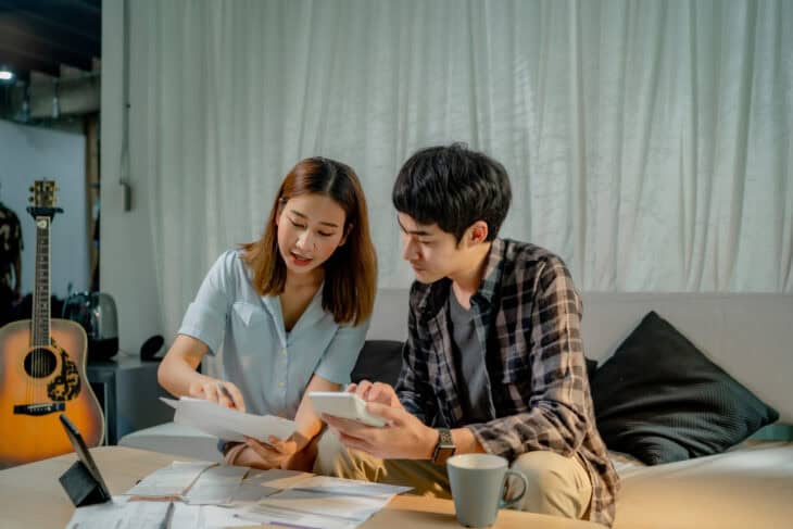 Two people calculating their finances and considering a term certificate as a savings option.