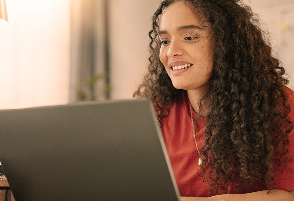 Woman in red shirt on laptop reading blog