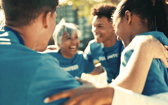 People with blue shirts in a group huddle