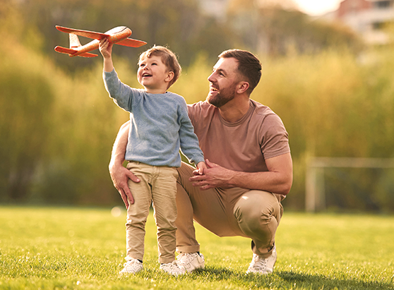 Father and son playing with toy plane