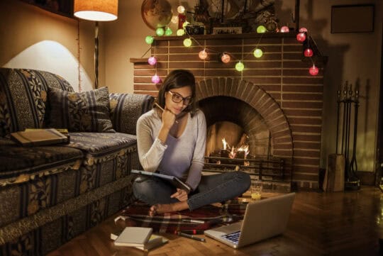 Person sitting in front of computer learning about holiday scams.