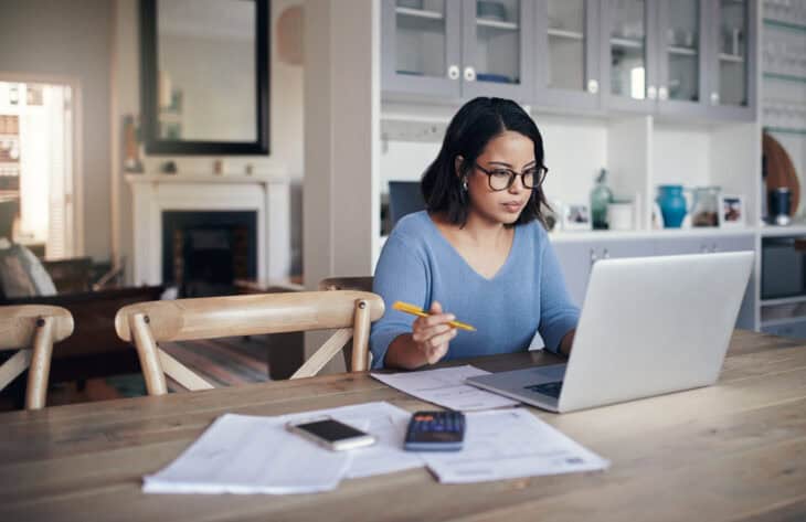 A person sitting at a laptop reviewing personal budgeting tools.