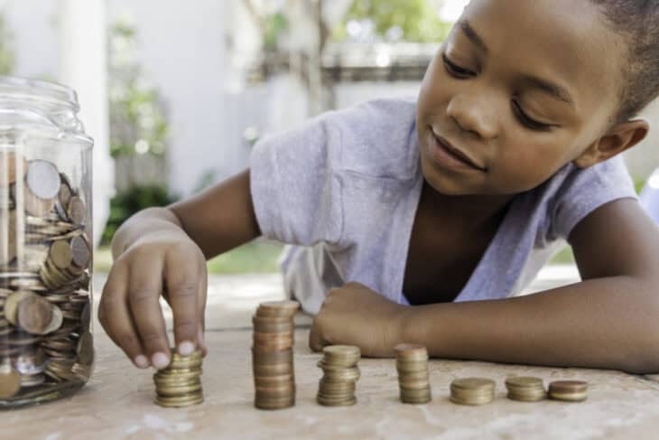 A child counting coins and learning how to save money.