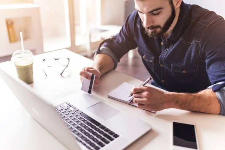 Person sitting in front of a computer checking their credit score.