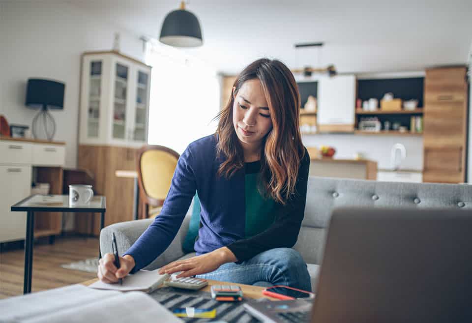 Woman sitting on couch preparing tax return